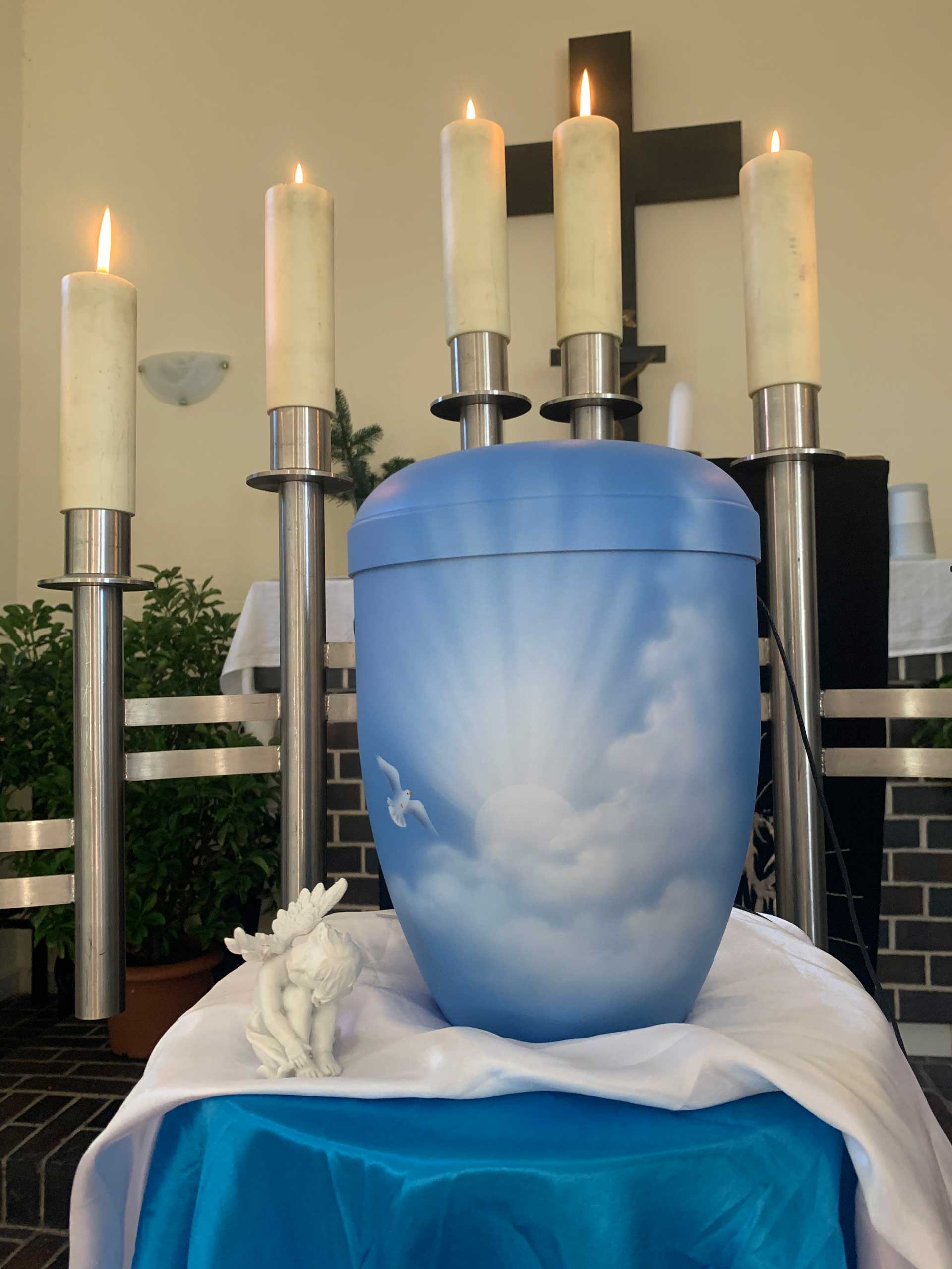 Mit einer Illustration des Himmels verzierte Urne aufgebahrt in der Kirche.